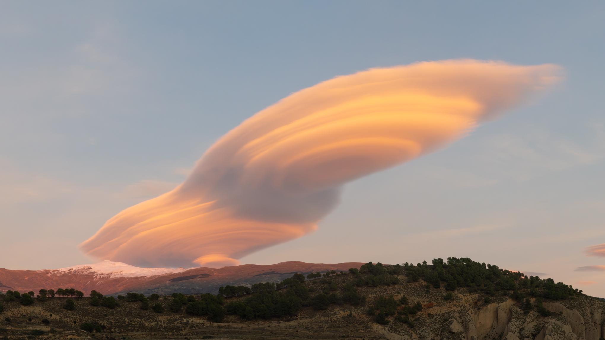 Lenticular cloud over Conchar. Lenticular clouds often resemble alien spacecraft from some sci-fi movie - they are caused by rapidly cooling air over the mountains sculpting any low lying clouds into fantastical formations.